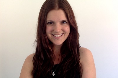 Katherine Ellliston is smiling. She has long dark hair and is wearing a black sleeveless top.