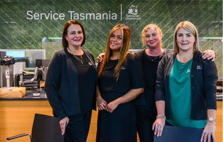 Four staff from the Glenorchy Service Centre pose together in front of their service desk