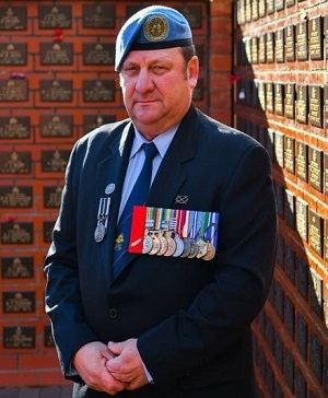 Peter Williams is standing in front of a memorial wall