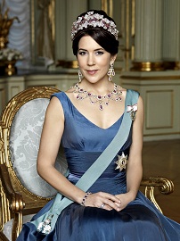 HRH Crown Princess Mary of Denmark is seated and wearing a Royal blue satin dress