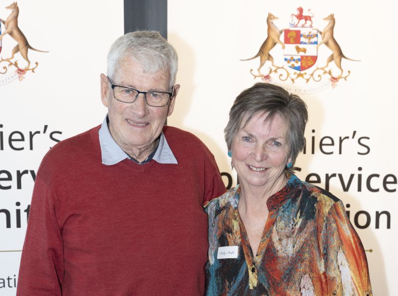 An award recipient and her husband pose in front of banners at the 2025 Northwest Premier's Long Service Recognition event