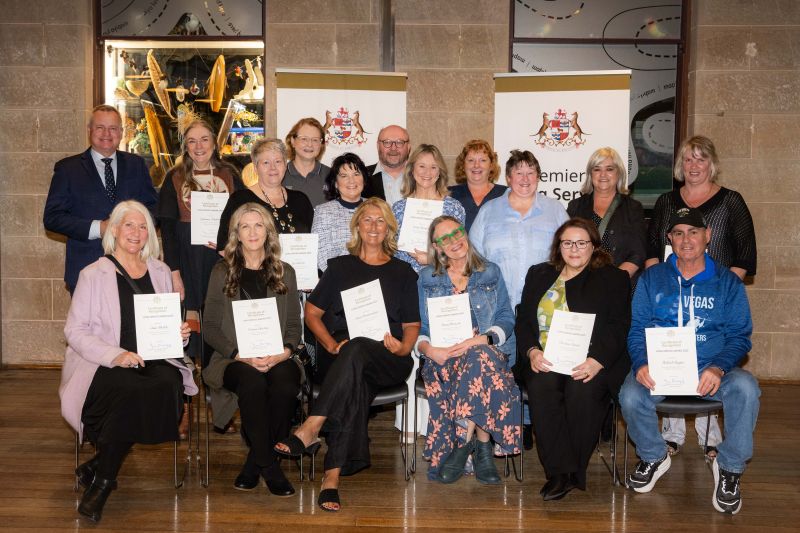 The premier and award approximately 15 recipients pose with certificates in front of banners that read Premier's Long Service Recognition at the southern 2025 event