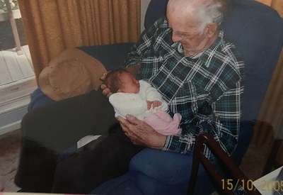 A baby being held by an elderly man