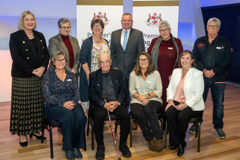 The premier and award recipients pose in front of banners that read Premier's Long Service Recognition at the northern event in 2025