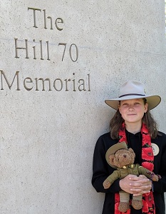 Nell Hentschel holding at teddy bear in military uniform at the Hill 70 Memorial