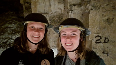 Two young women wearing helmets in a tunnel
