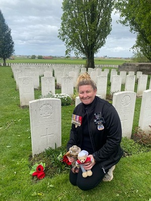 A woman kneelling by the graveside of Albert Walker