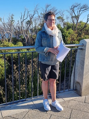Shelley Hollister is standing and reading a report 