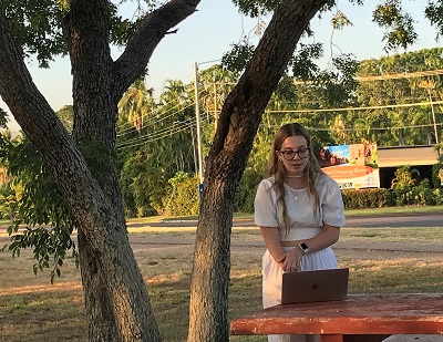 Hollie James presenting research in an outdoor tropical setting