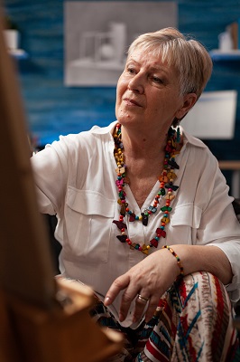 An older woman painting 